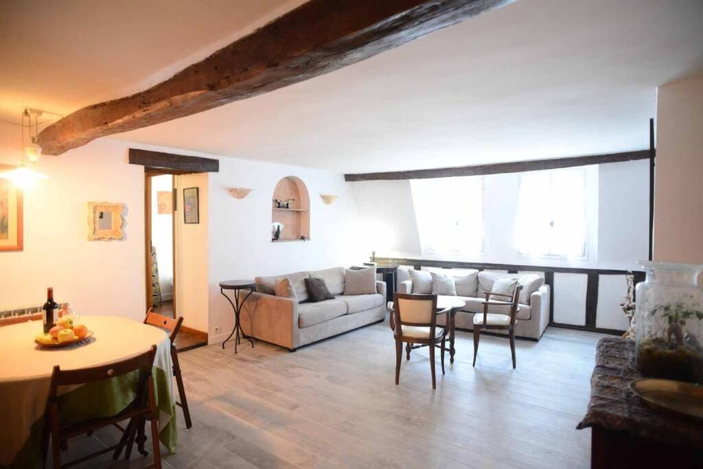 un salon avec un canapé, une table et des chaises dans l'établissement Typical Marais 3 bedroom - Beaubourg, à Paris