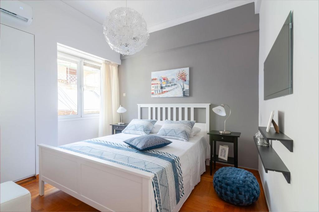 アテネにあるElpis by Heloni Apartmentsの白いベッドルーム(青い枕のベッド付)