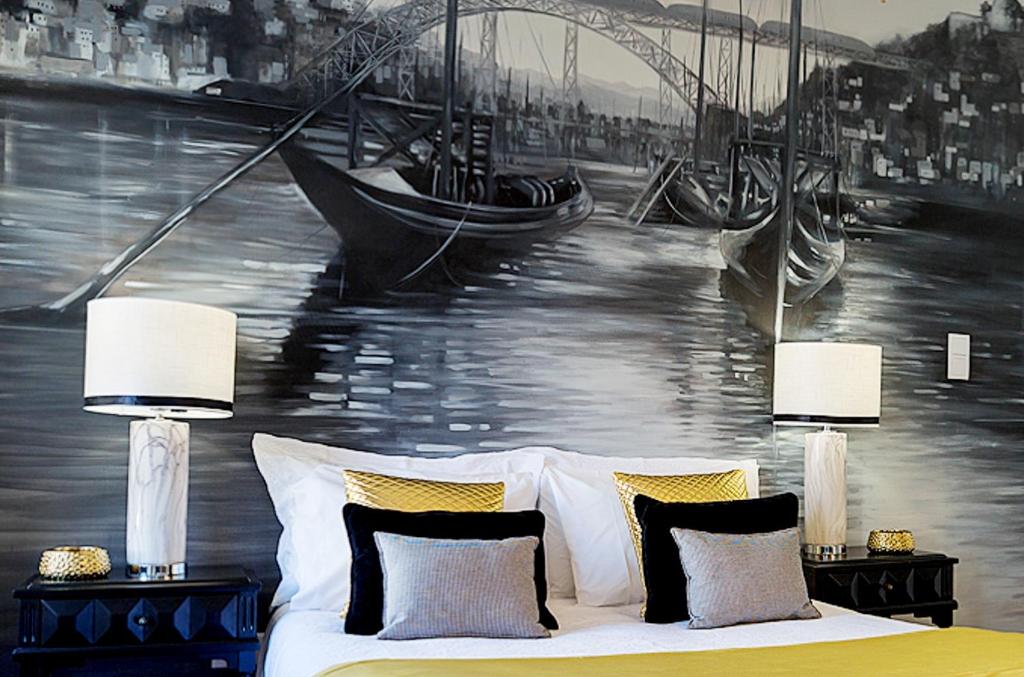 a bedroom with a painting of a river and a boat at the gallery Studios II in Porto