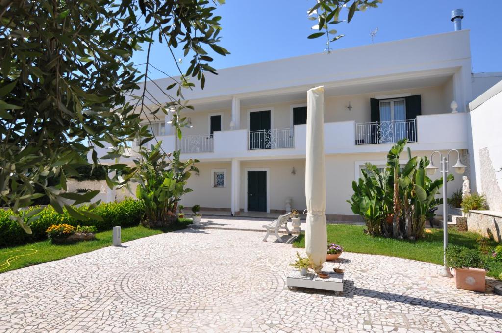 un gran edificio blanco con una columna en el patio en Villa Marcella Room, en Porto Cesareo