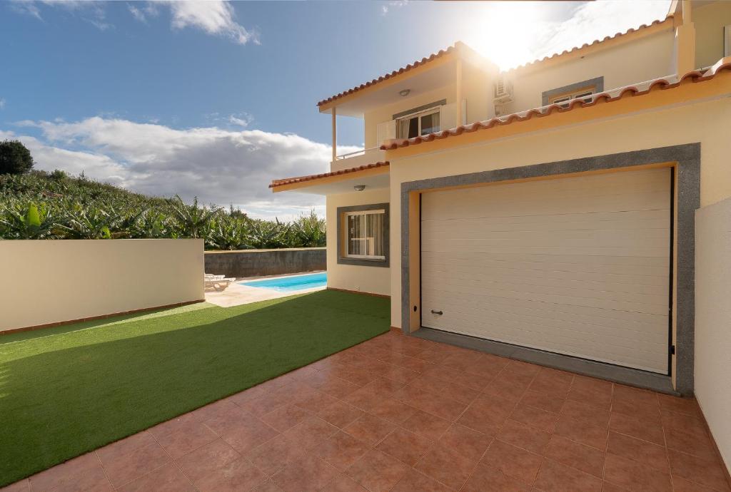 a garage door in a house with a yard at Arco da Calheta Villa in Arco da Calheta