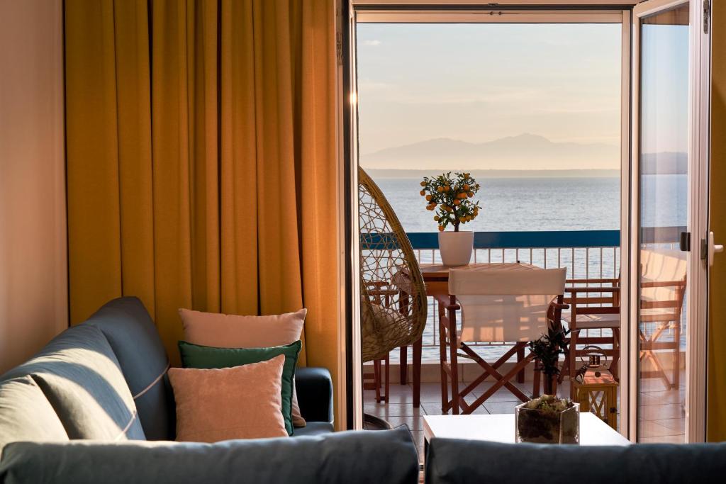 a living room with a couch and a view of the ocean at Seafront Luxury President Suite Aegean Sunset in Thessaloniki