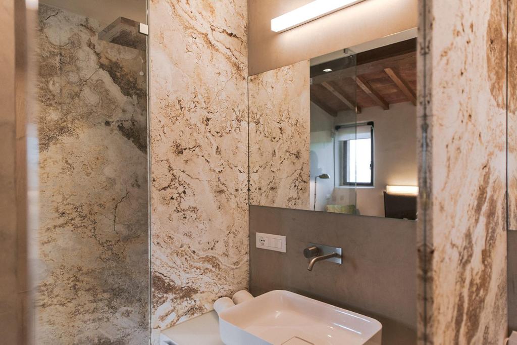 a bathroom with a sink and a mirror at Torre di Baratti Bio Resort in Populonia