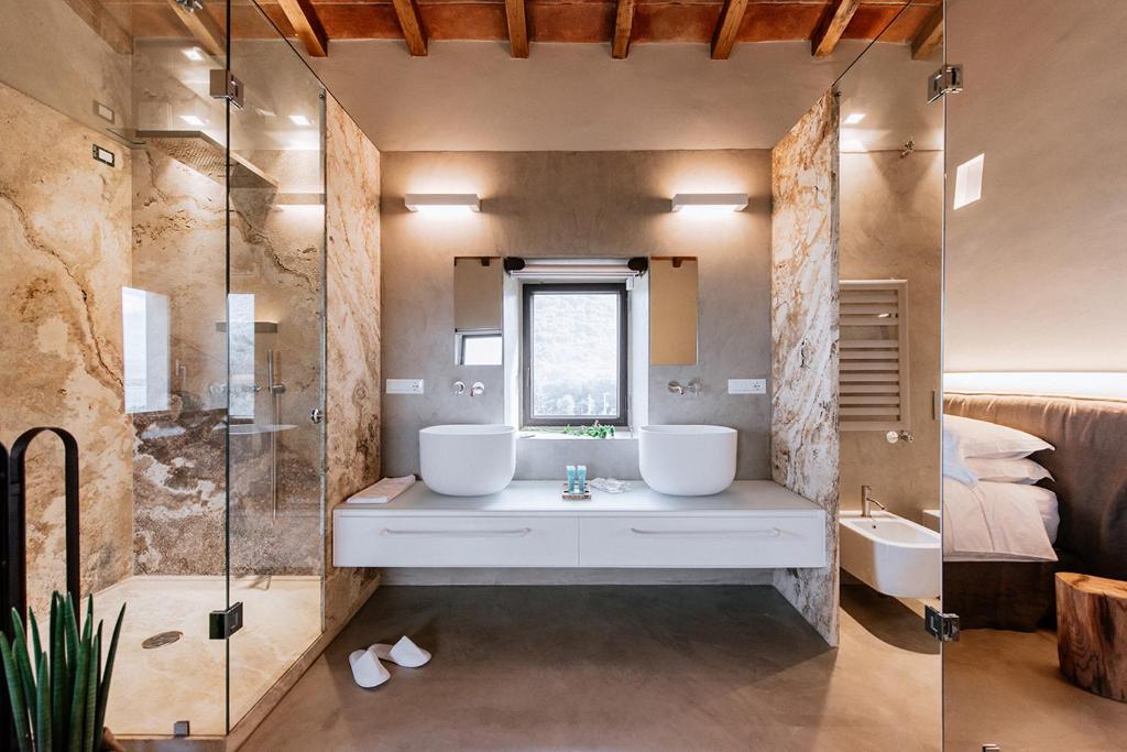 a bathroom with two sinks and a shower at Torre di Baratti Bio Resort in Populonia