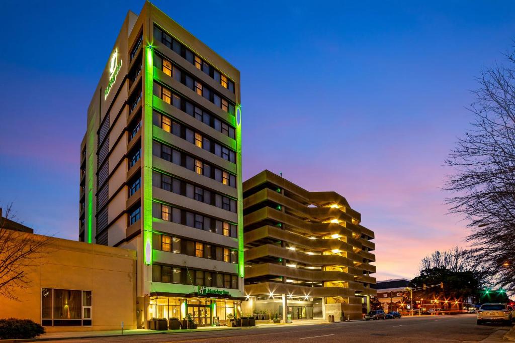 Holiday Inn - Columbia - Downtown, an IHG Hotel في كولومبيا: مبنى طويل وبه أضواء خضراء