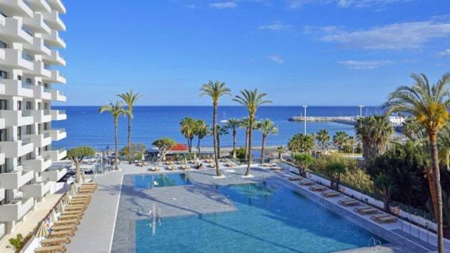 トレモリノスにあるApartamento privado en Hotel Sol Alohaのスイミングプールと海を望むリゾートです。