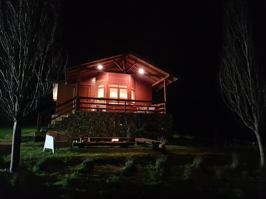 una casa de madera por la noche con luces encendidas en Landecoira, en Sequeiro