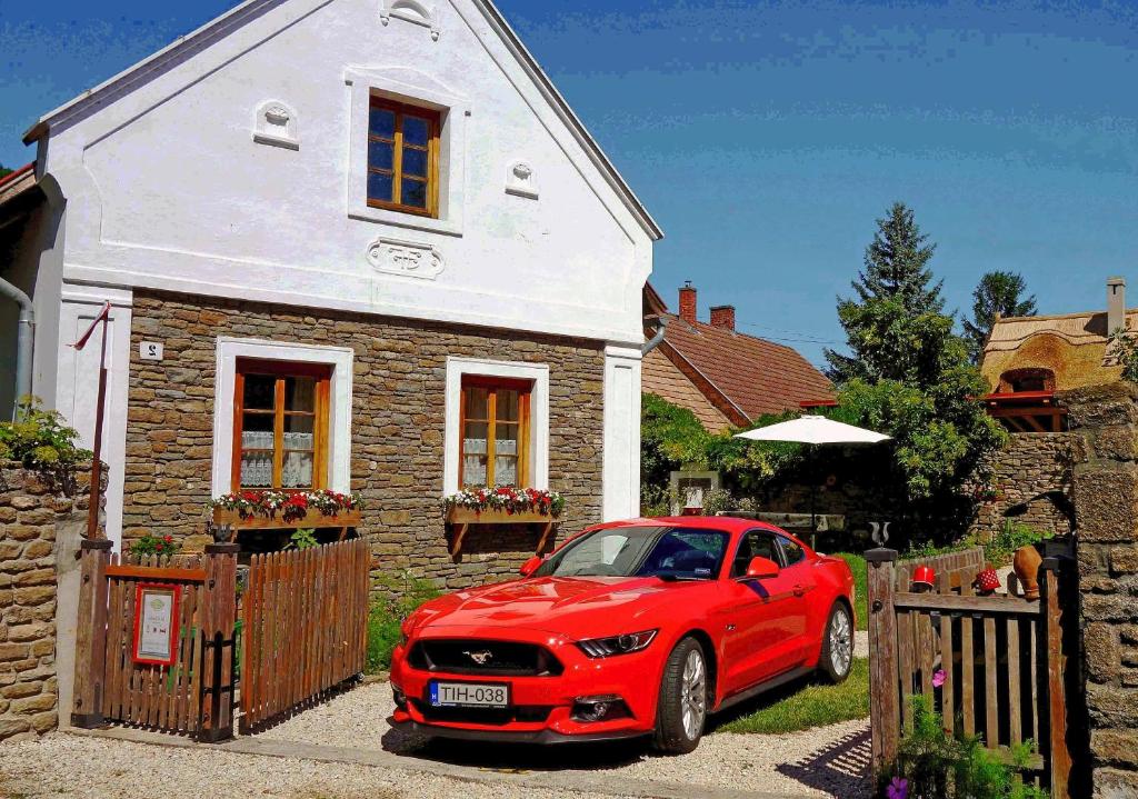 a red car parked in front of a house at B B Guesthouse TIHANY in Tihany