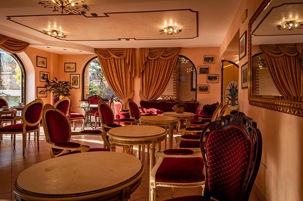 restauracja ze stołami i krzesłami w pokoju w obiekcie Hotel Louis II w Ciampino