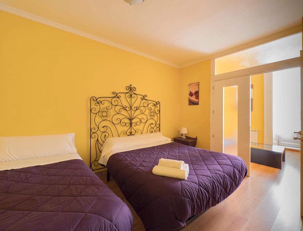 1 dormitorio con 2 camas con sábanas moradas en Pensión Apolo XI, en Madrid