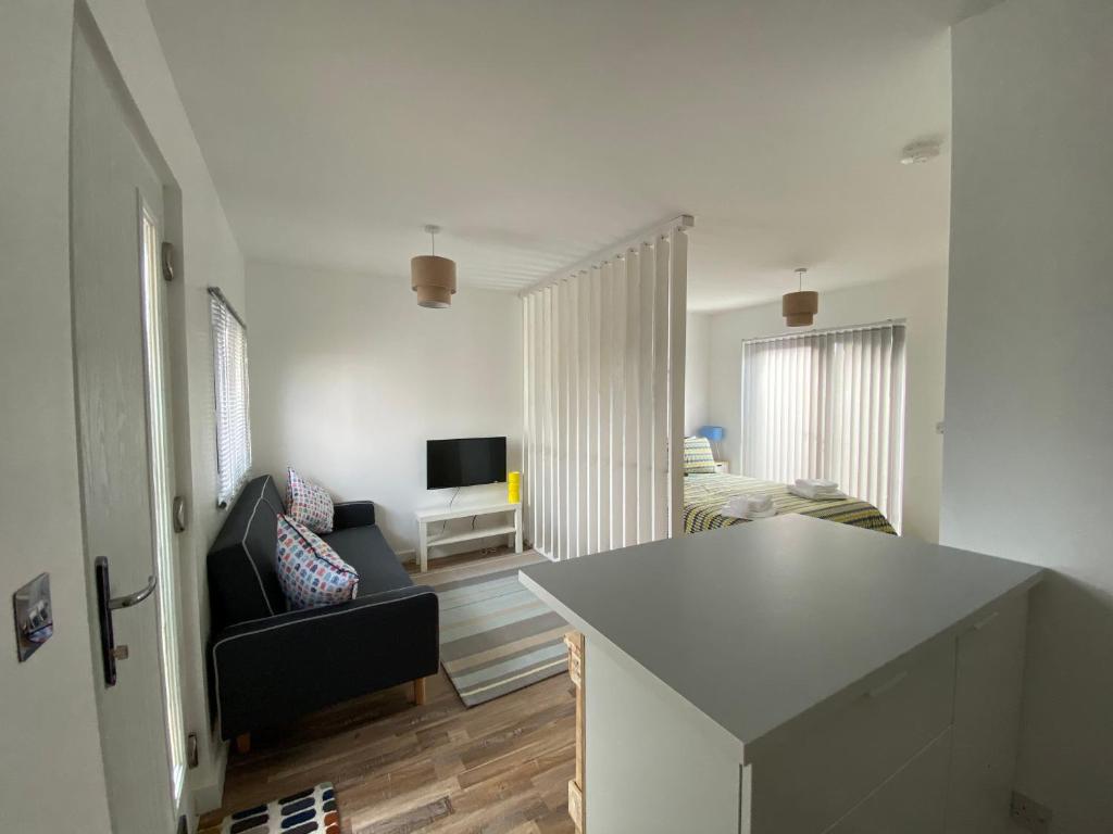 a kitchen and living room with a couch and a television at Margate Seaside Retreat in Margate