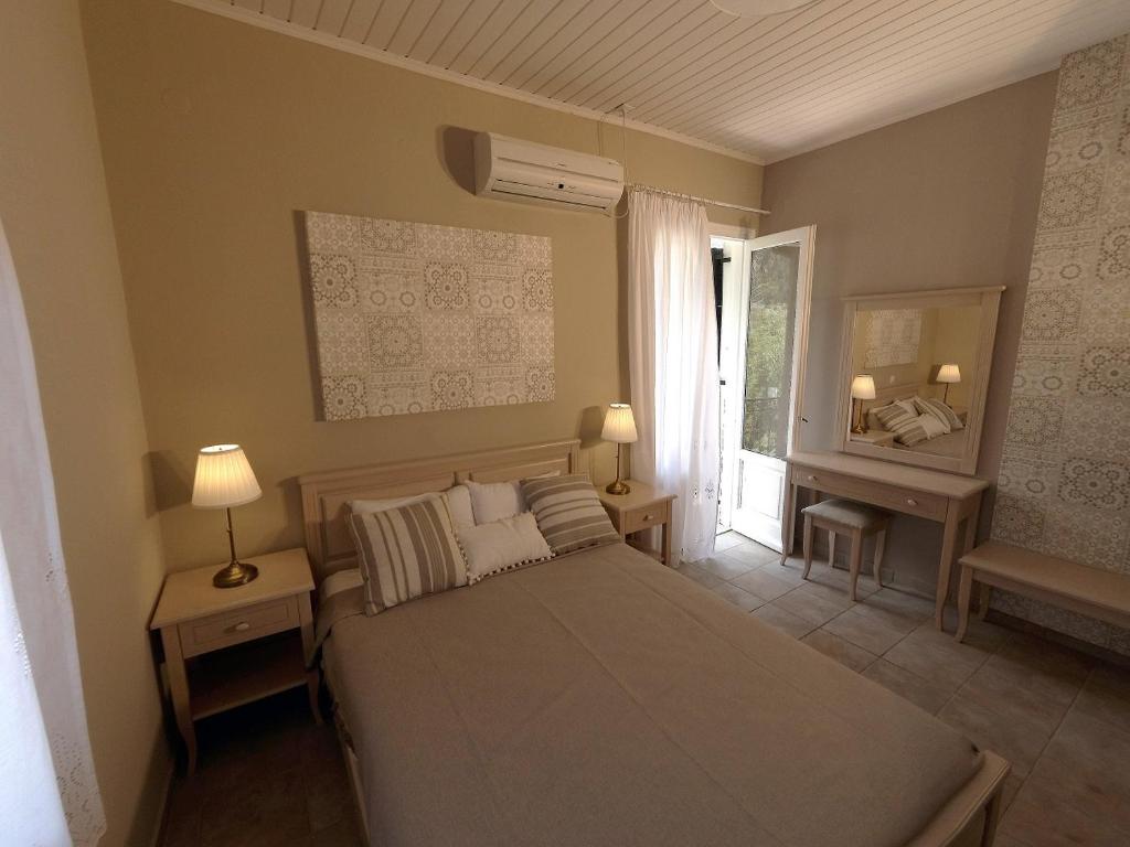 een slaapkamer met een bed met 2 lampen en een raam bij House of Garden in Draganon