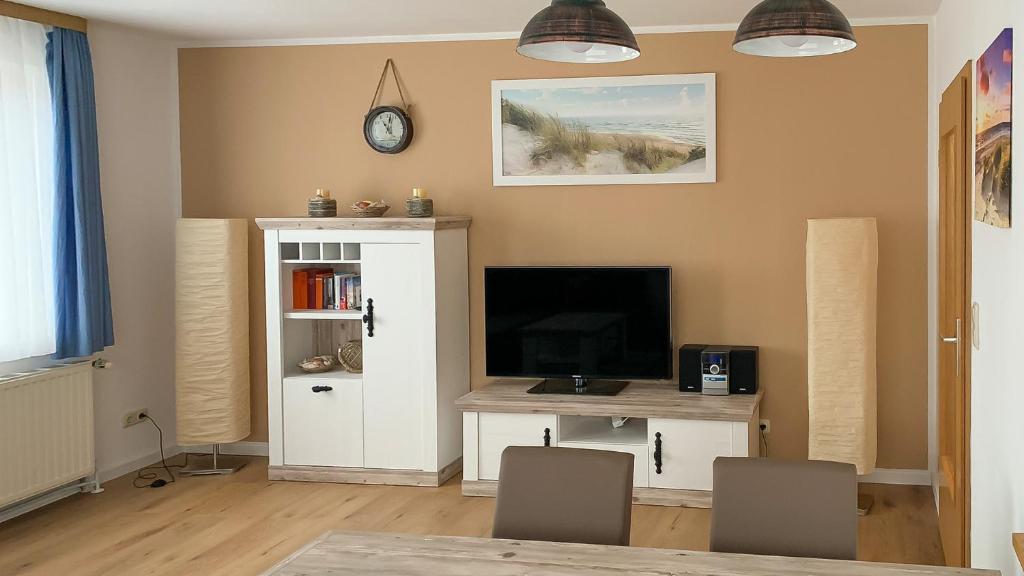 a living room with a tv and a desk with a television at Strandnahe, familienfreundliche Ferienwohnung auf Usedom in Koserow in Ostseebad Koserow