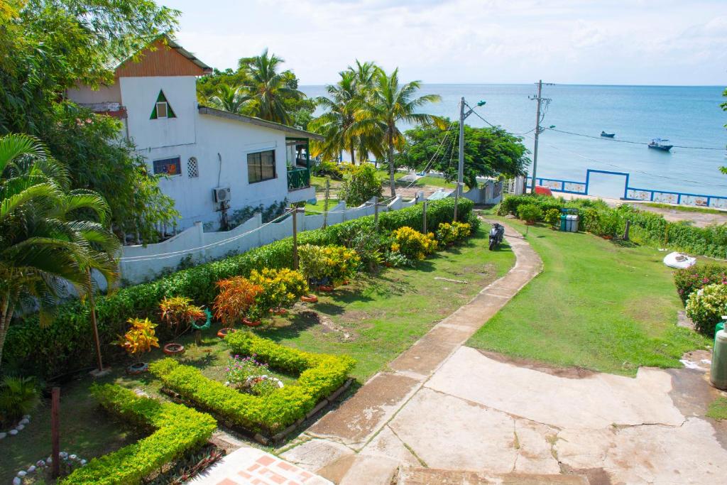 a garden in front of a house next to the ocean at Posada Sweet Anashly in Providencia