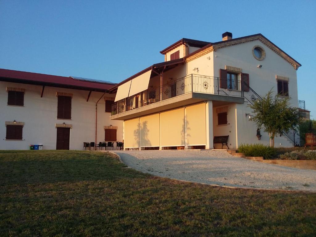 ein großes weißes Haus mit einem Balkon an der Seite in der Unterkunft B&B Itufi in Colonnella