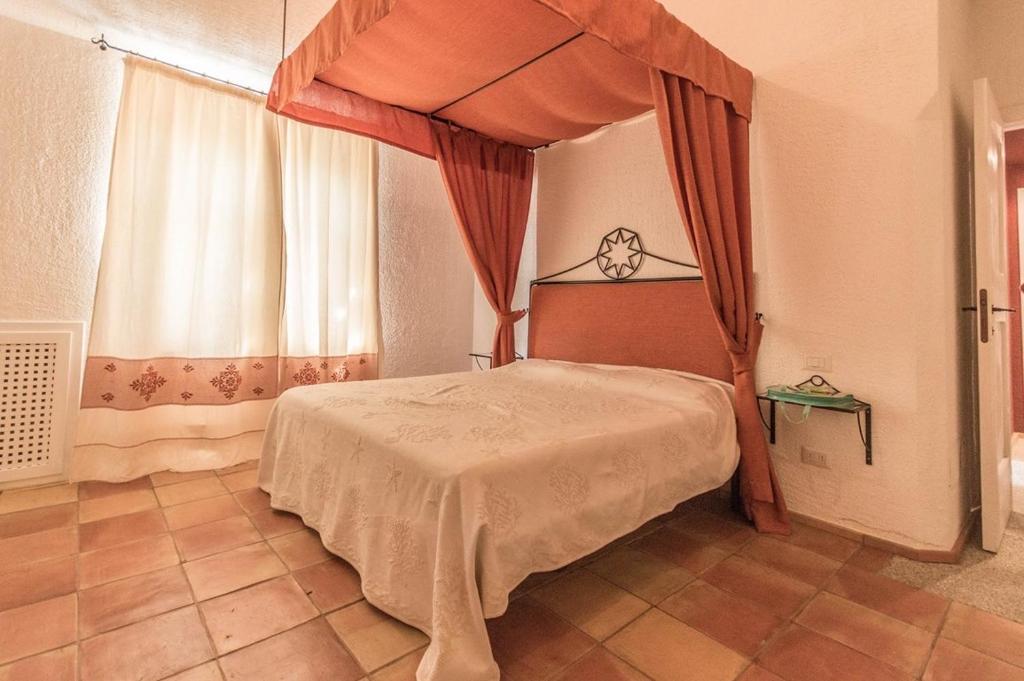 1 dormitorio con 1 cama frente a una ventana en Villa Bianca, en Arzachena
