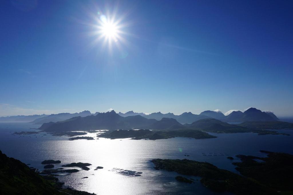 vistas a un lago con el sol en el cielo en Knut Ellingsen, en Reine