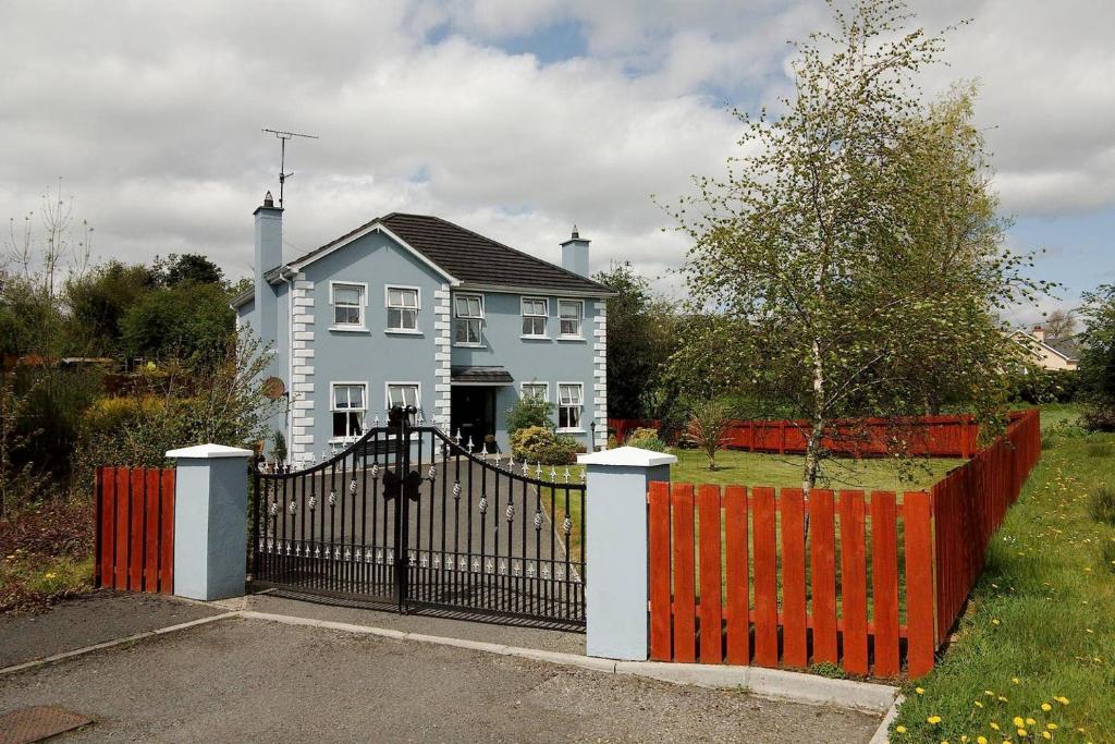 una casa blanca con una puerta roja delante de ella en Sessiagh House en Castlefinn