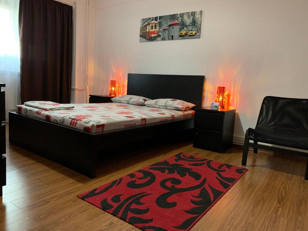 a bedroom with a bed and a red rug at Center Apartment in Galaţi