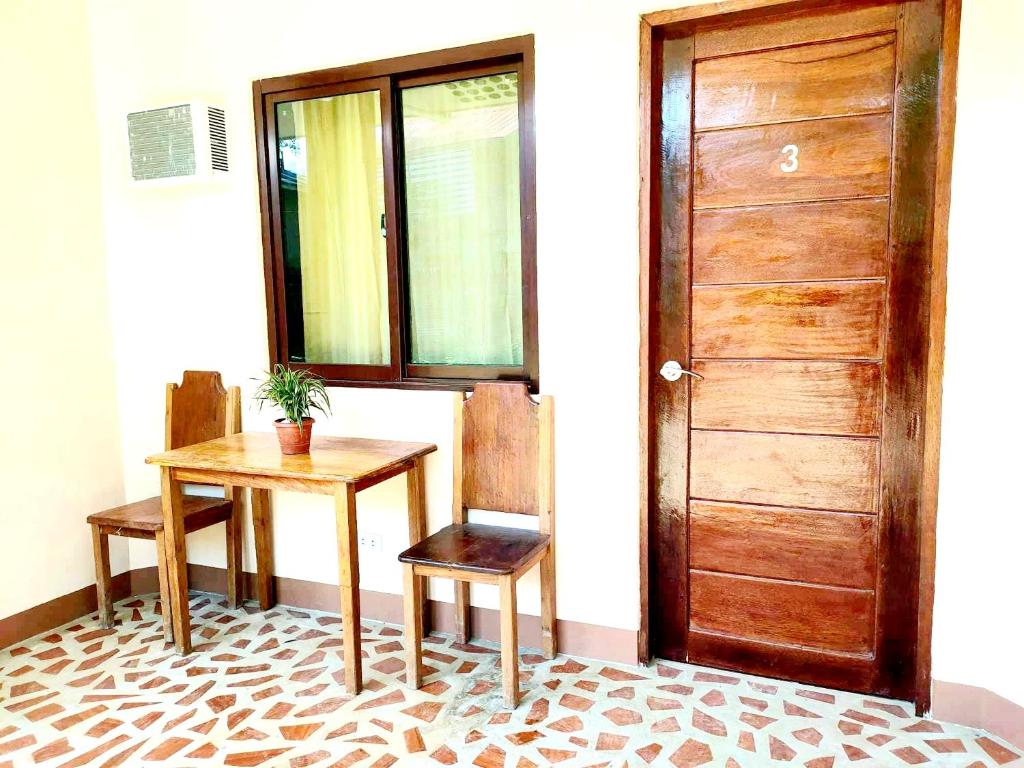 a room with a table and a wooden door at Two Season Tourist Inn in San Vicente