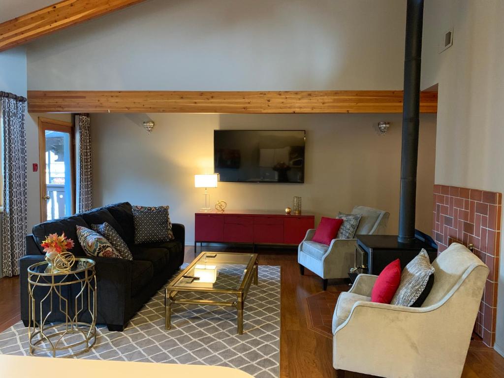a living room with two couches and a fireplace at Der Sportsmann Suites in Leavenworth