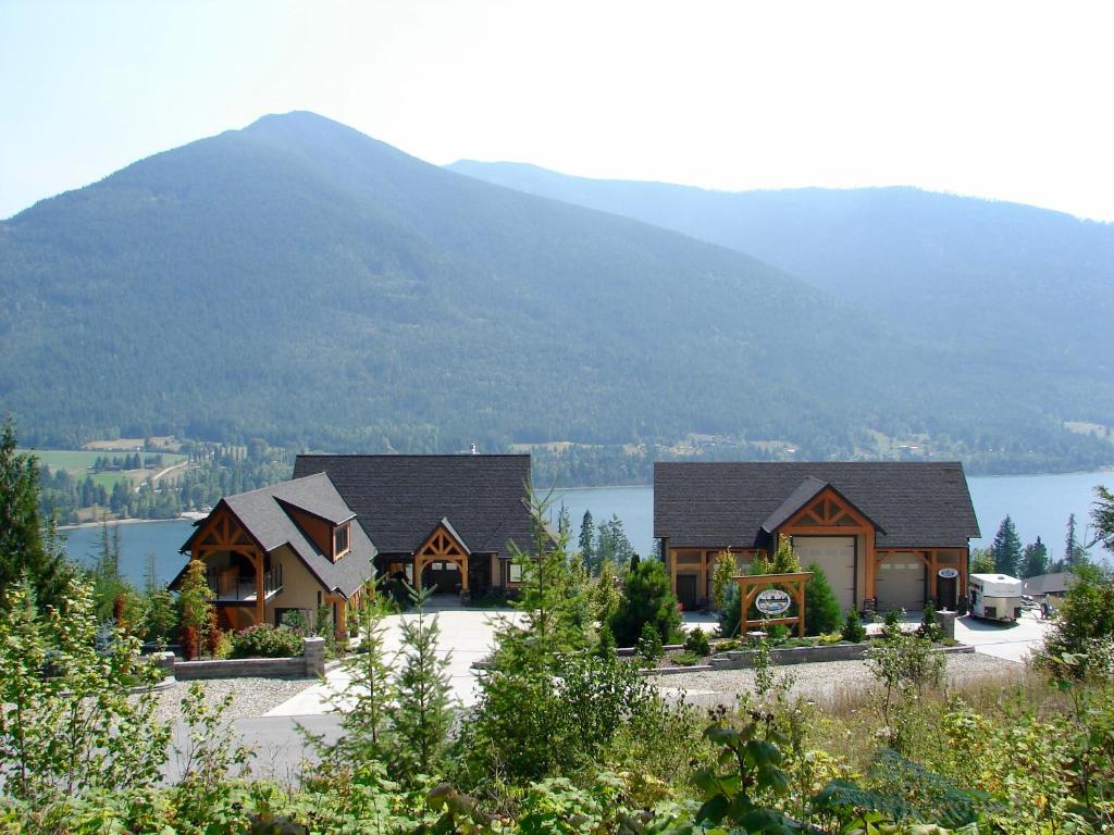 a large house with a mountain in the background at Kootenay Wild Guest Suites in Nelson