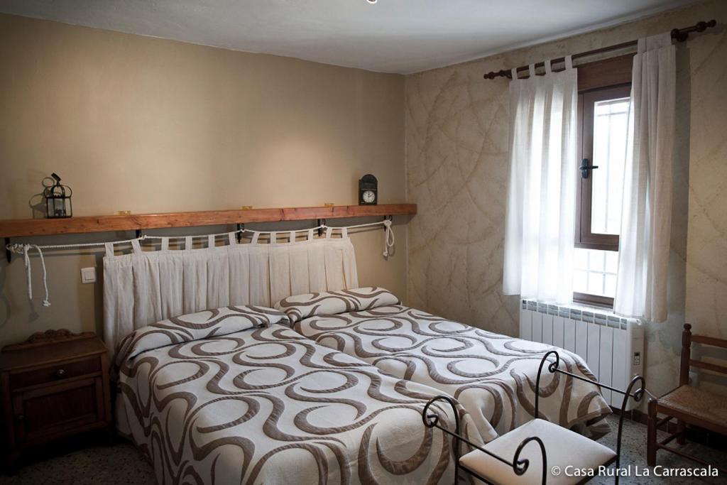 Schlafzimmer mit einem Bett und einem Fenster in der Unterkunft Casa Rural La Carrascala in Zamora