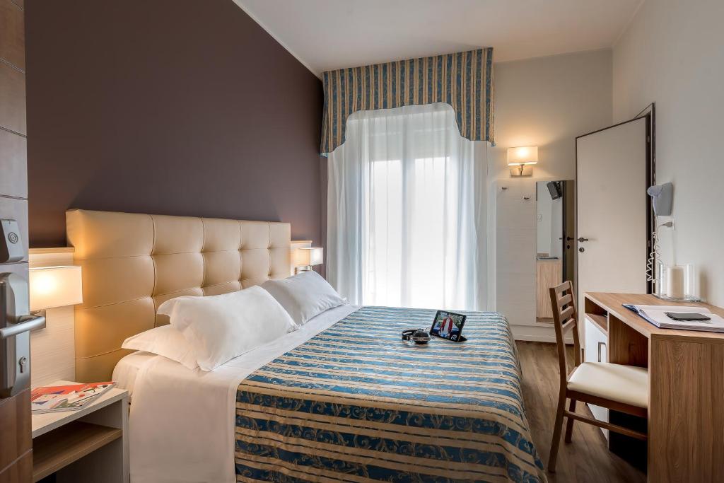 a hotel room with a large bed and a window at Hotel Sole Mio in Rimini