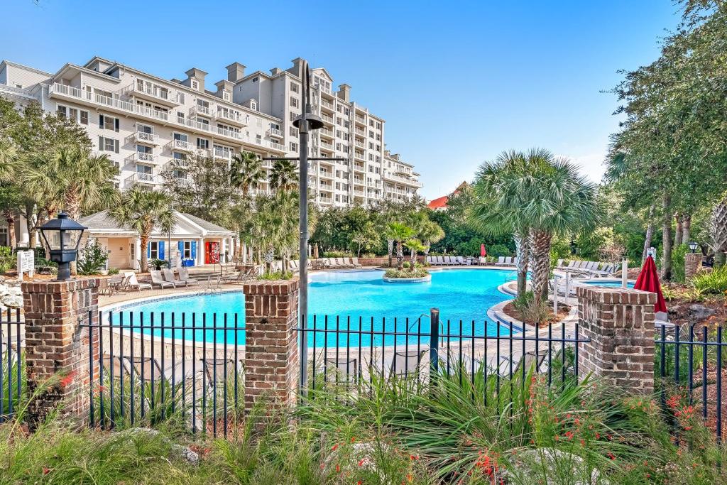 a swimming pool with a fence and a building at Bahia Condos in Destin