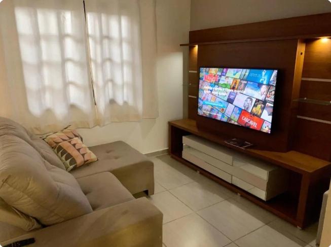 sala de estar con sofá y TV de pantalla plana en Apto Funcional próximo a Orla do Centro HS1 en Ubatuba