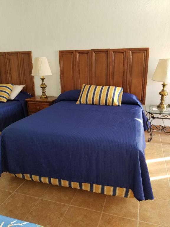 - une chambre avec 2 lits avec des draps bleus et 2 lampes dans l'établissement Vistas de Loreto, à Loreto