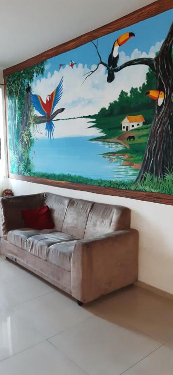 una pintura en la pared con un sofá en una habitación en Apto 1,5 km do Shop. Manauara, en Manaus