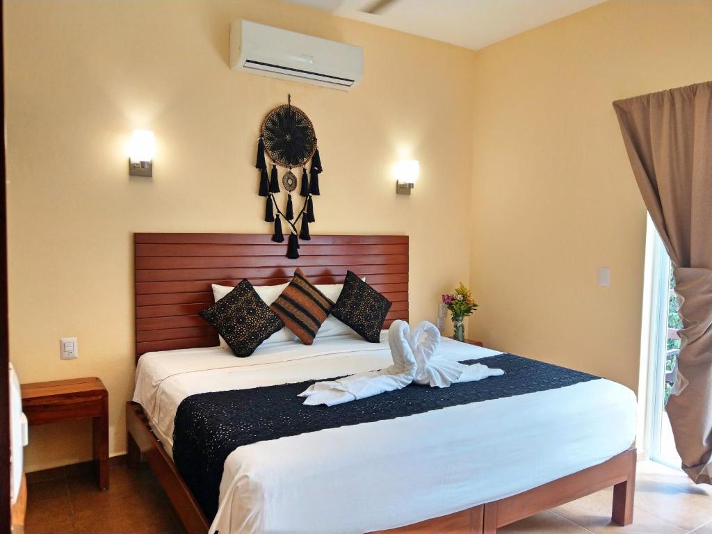 a bedroom with a bed with a cross on the wall at Tulum Nah in Tulum