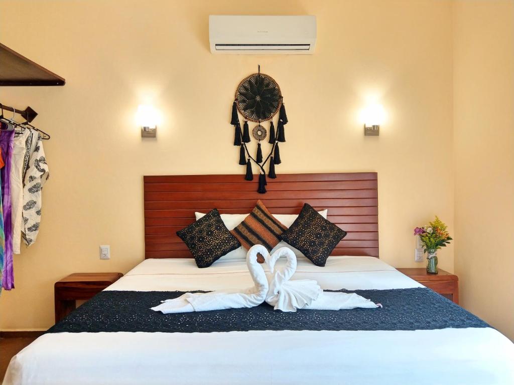 two swans towels on a bed in a room at Tulum Nah in Tulum