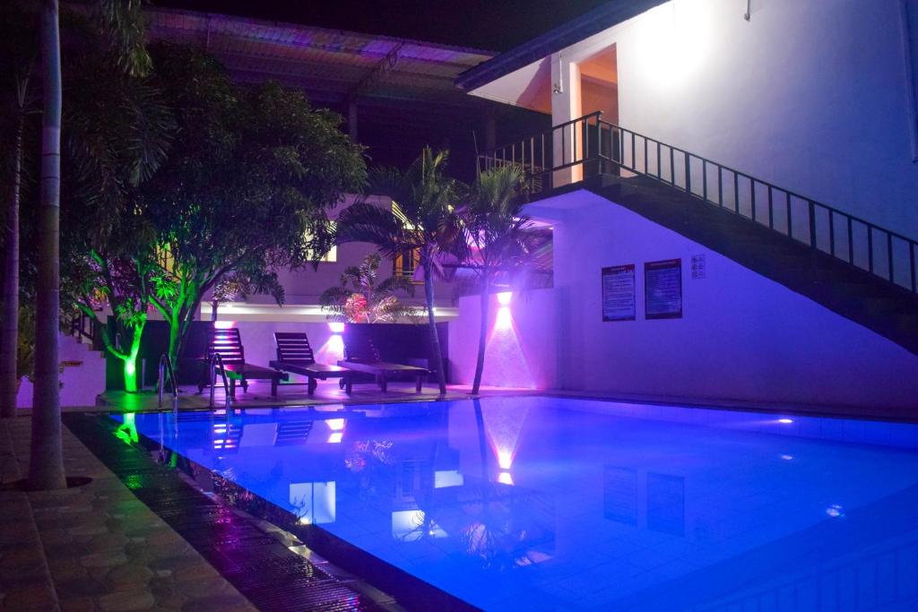 a swimming pool lit up at night with lights at Lion Resort in Polonnaruwa