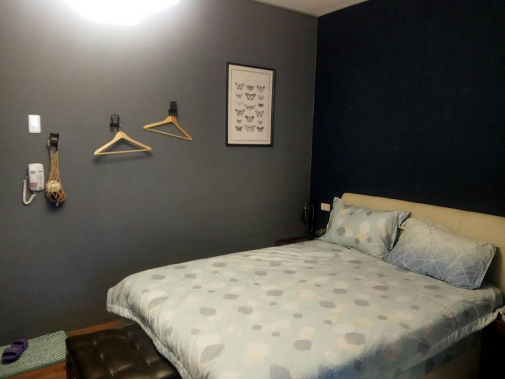 ein Schlafzimmer mit einem Bett und einer Wand mit Kleiderbügeln in der Unterkunft 悠然宅 in Tainan