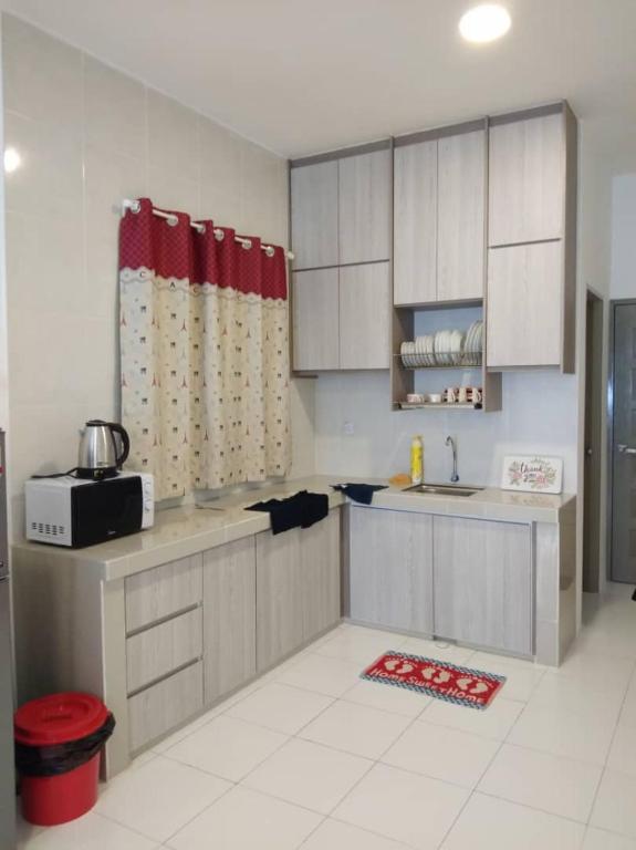 a kitchen with white cabinets and a sink at Rose Apartment Keafarm in Cameron Highlands