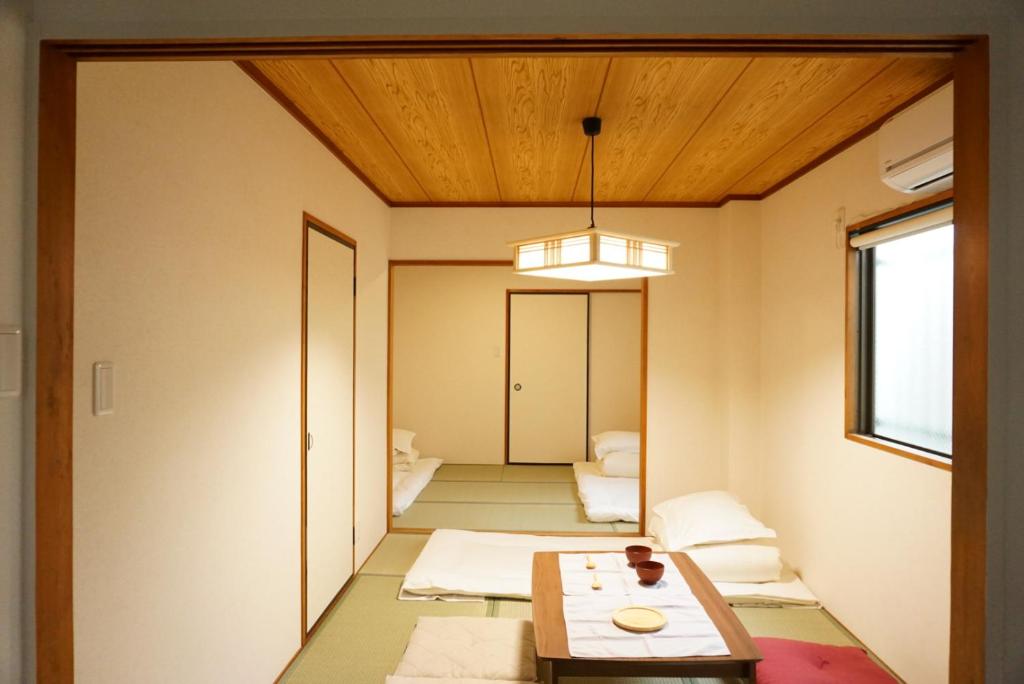 a room with a table and a room with a hallway at SYOGA A house, next to natural park in Osaka