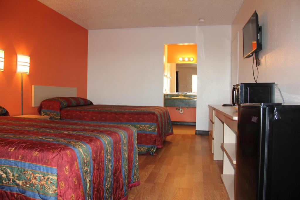 Cette chambre comprend deux lits et une télévision. dans l'établissement Sherman Inn, à Sherman