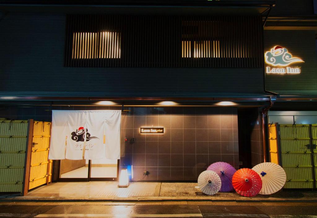un gruppo di ombrelli seduti di fronte a un edificio di Laon Inn Gion Nawate a Kyoto