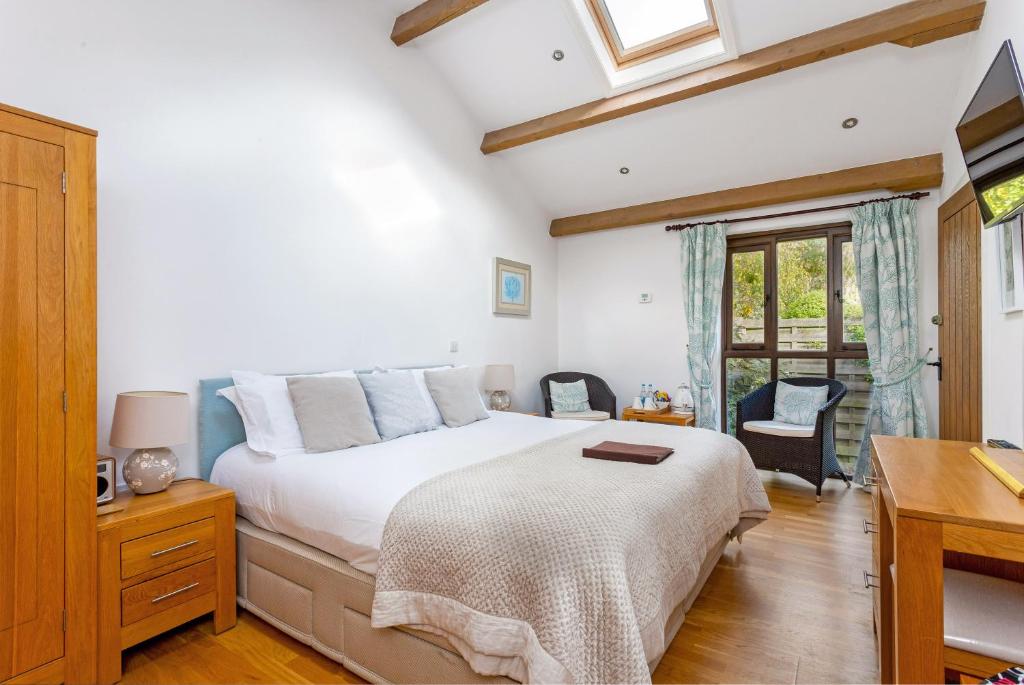 a bedroom with a bed and a desk and a window at Lockgate Dairy in Chichester