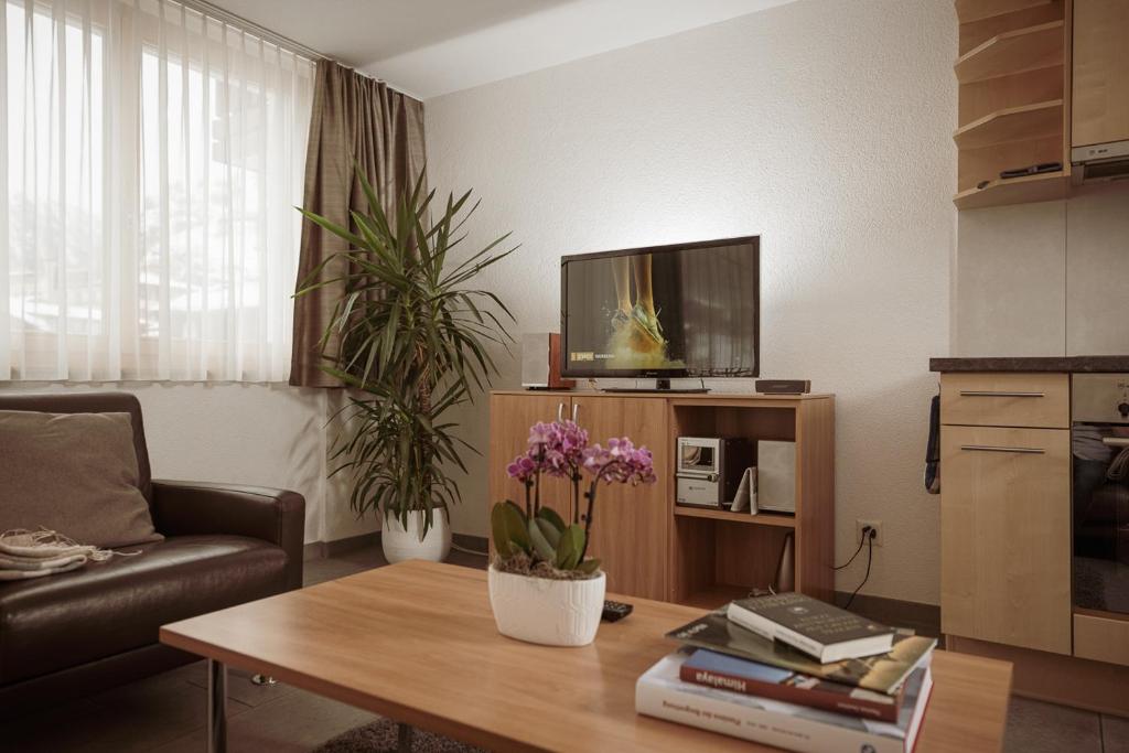 a living room with a table and a tv at Haus Mischabel in Zermatt