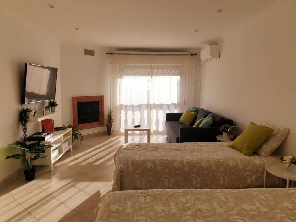 - un grand salon avec un lit et un canapé dans l'établissement Sunny Setúbal Apartments, à Setúbal