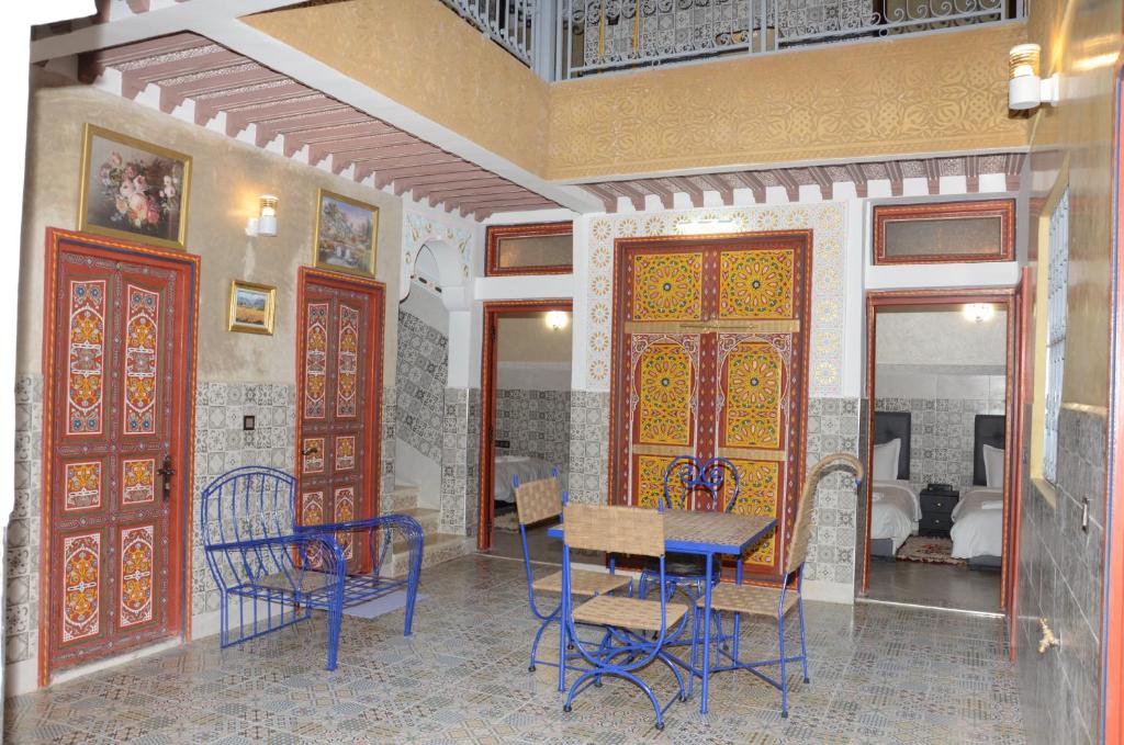 comedor con mesa, sillas y puertas en Riad Rayan's Guests, en Marrakech
