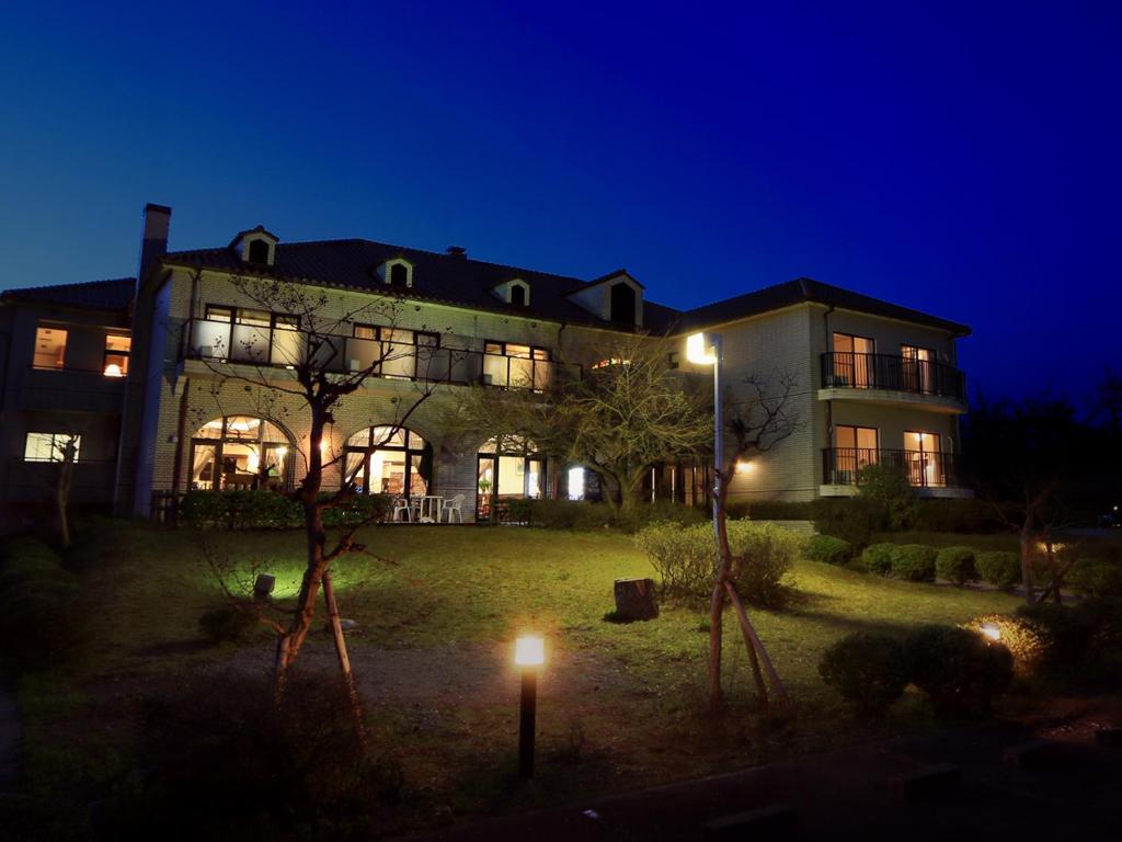 una casa grande por la noche con luces en el patio en Reposer makino, en Takashima