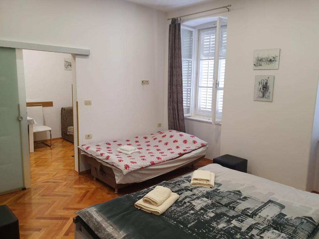 a bedroom with two beds and a window at Apartmani Tower in Rijeka