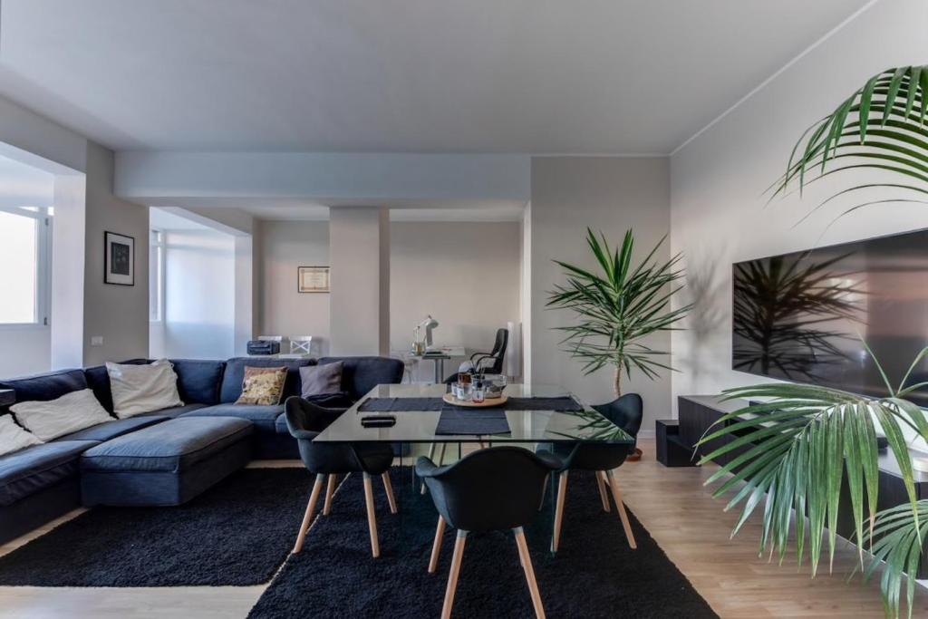 a living room with a blue couch and a table at Camera Deluxe in favoloso attico vista mare in Rimini