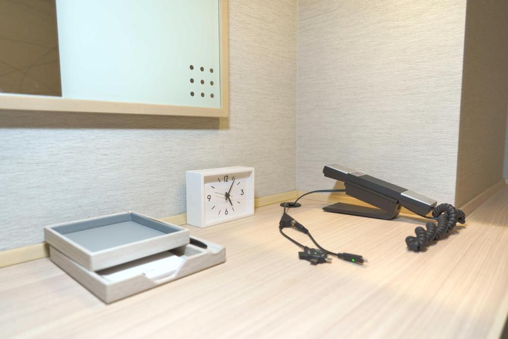 a camera and a gun next to a clock at Meitetsu Inn Hamamatsucho in Tokyo