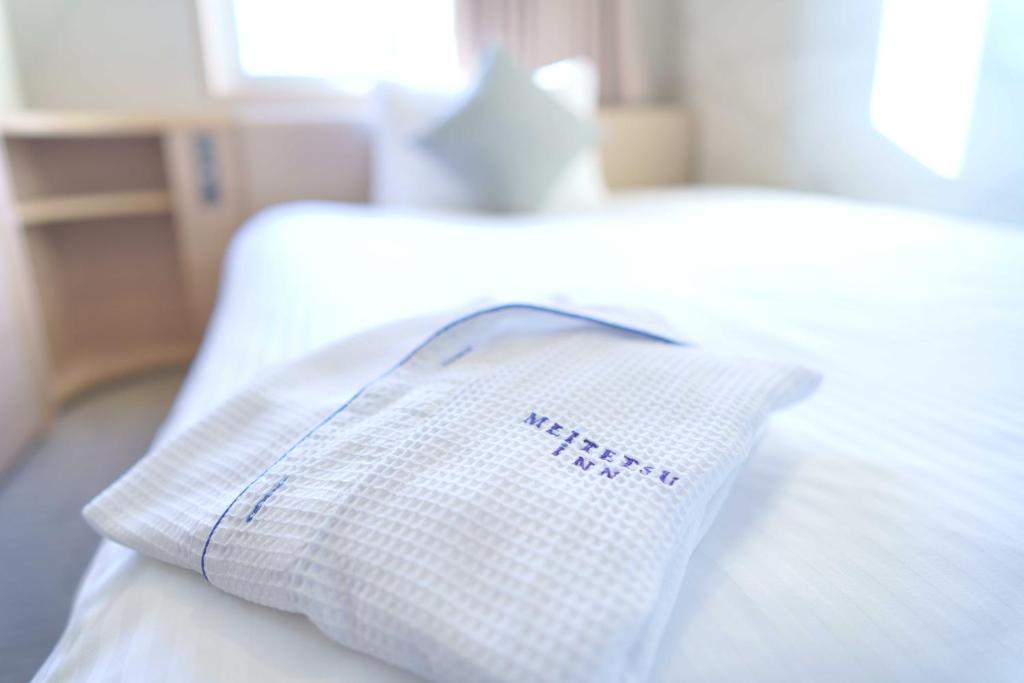 a white pillow sitting on top of a bed at Meitetsu Inn Hamamatsucho in Tokyo