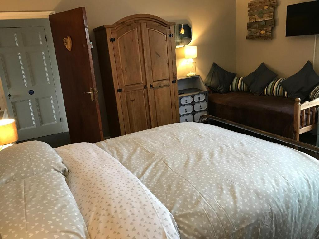 a bedroom with a bed and a couch in it at Kelston Guest House in Weymouth